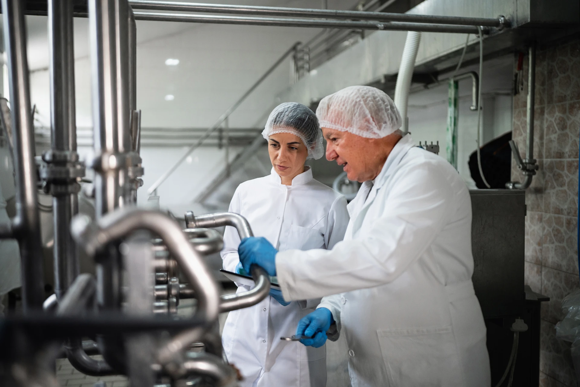 Zwei Mitarbeiter von Oberland eG inspizieren und prüfen die Milchproduktion