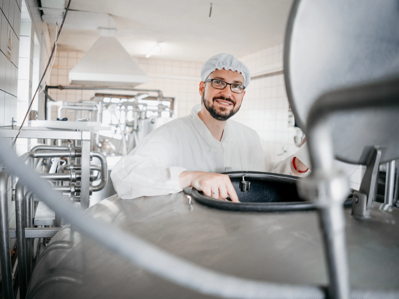 Ein Mitarbeiter der Firma Oberland eG überprüft einen Milchkessel